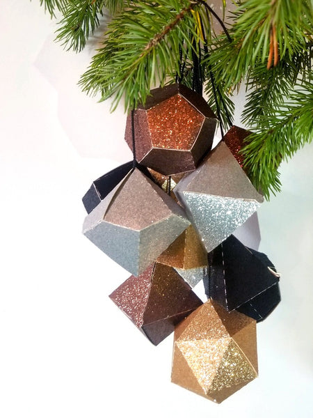 Metallic glitter dice boxes hanging in a cluster from a branch
