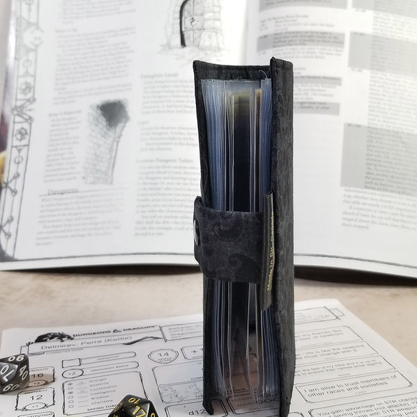 Side view of the black damask tarot sized spell book showing closure and interior pages.