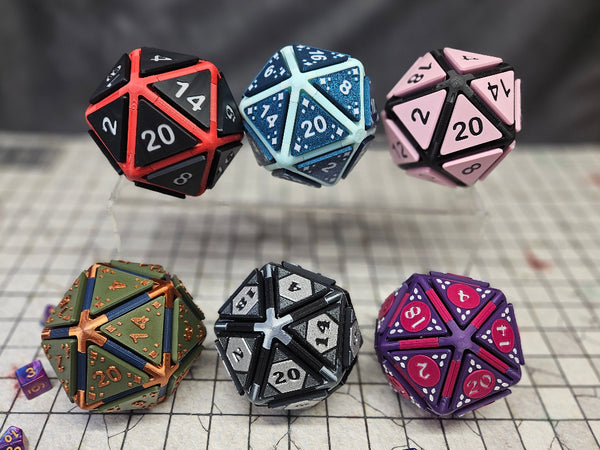6 D20 Fidget clickers with different colors and face patterns on a grid map background