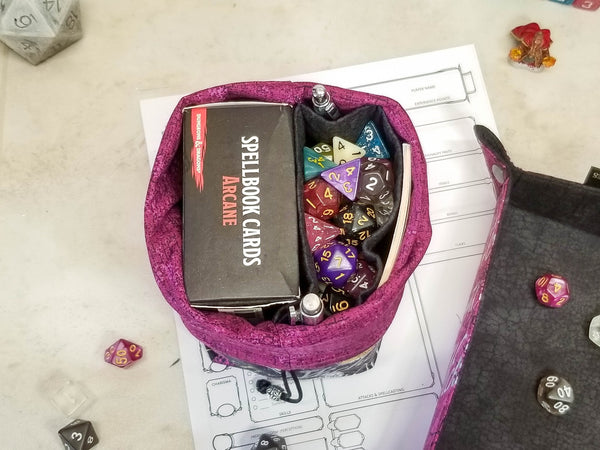 Halloween potions dice bag. Halloween print in black, metallic silver and purple with pops of gold. bag folded down to show purple lining