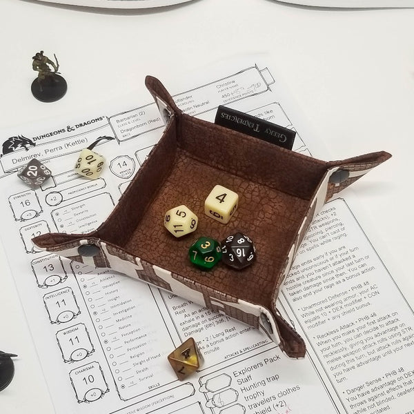Dungeon map print dice tray, lined with brown crackle fabric, shown with dice for scale
