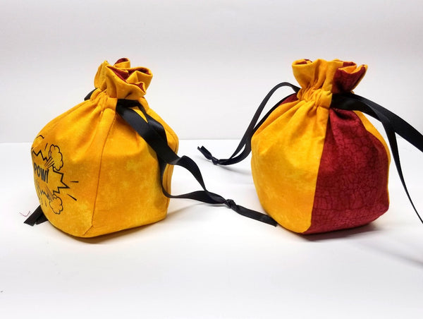 Two red and yellow dice bags, one with black custom graphic