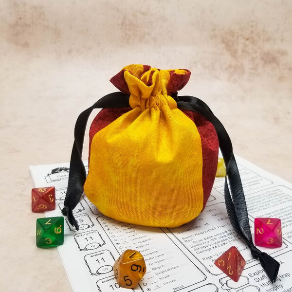 small yellow and red dice bag with black ribbon closure