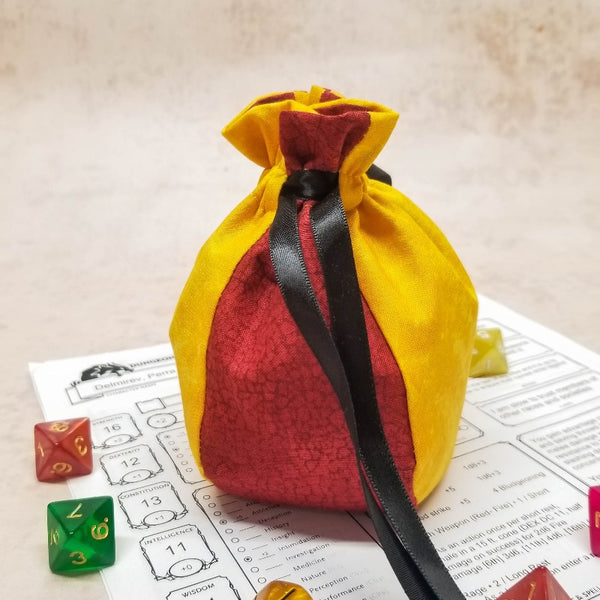 small red and yellow dice bag with black ribbon closure