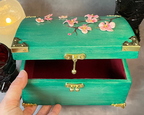 Cherry blossom chest in a shimmery mint green with 3D cherry blossoms and brass hardware.  Close up of latch